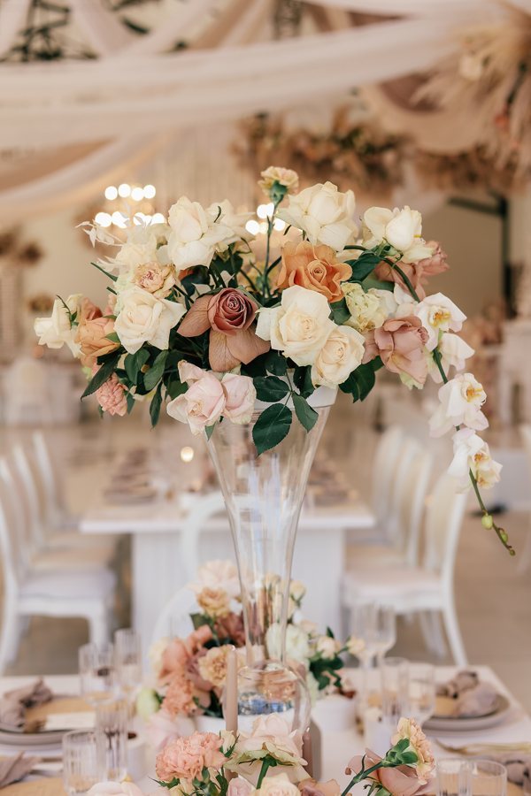 Elegant floral centrepieces with roses and orchids in a vase.