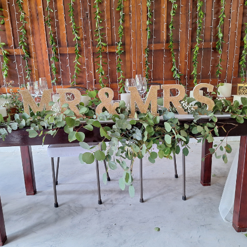 Top table with greenery and 'MR & MRS' decor