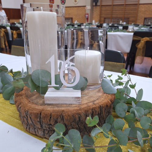 Table centerpiece with candles and eucalyptus on a wooden base