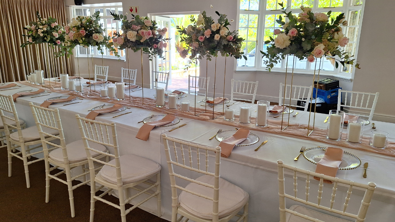 Long wedding table with floral arrangements and candles.