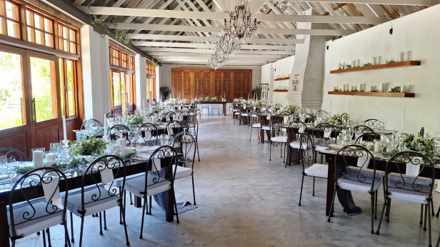 Decorated dining area with tables, chairs, and floral arrangements