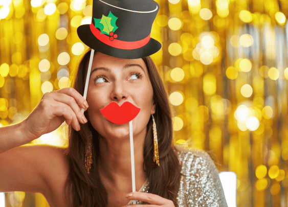 Woman with festive props in front of golden backdrop