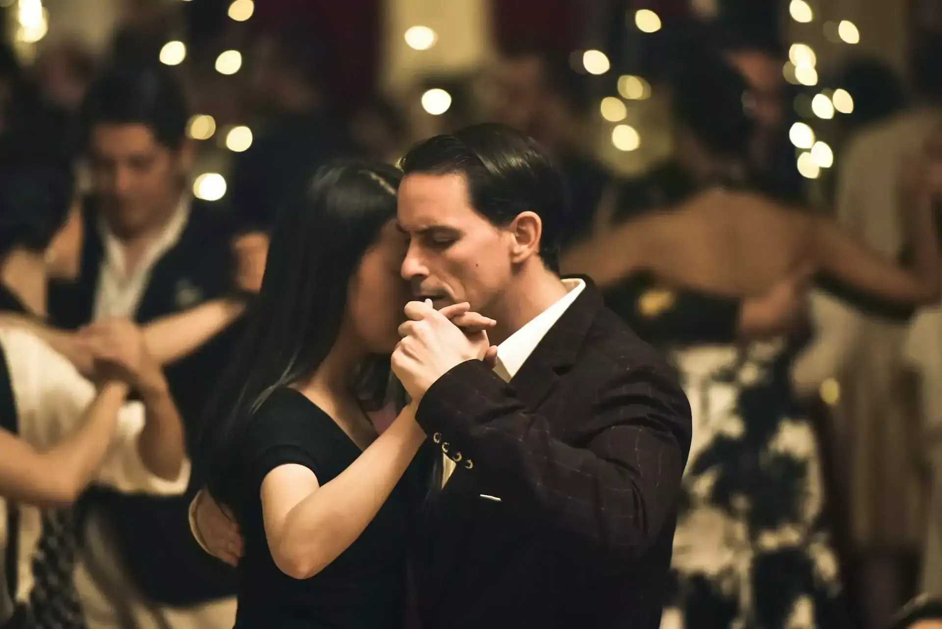 Couple dancing under decorative lighting at an event