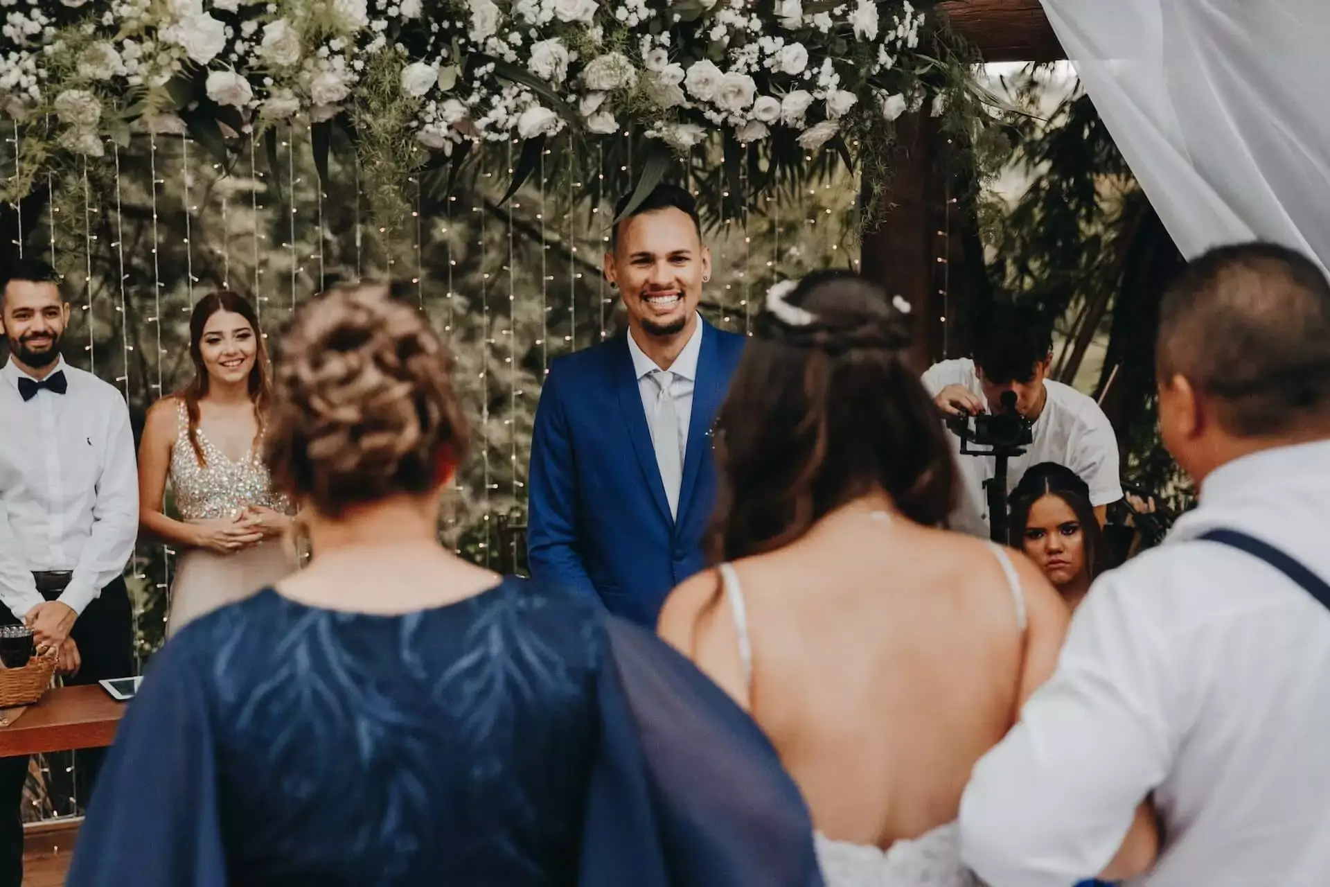 Wedding ceremony setup with floral decor and smiling groom