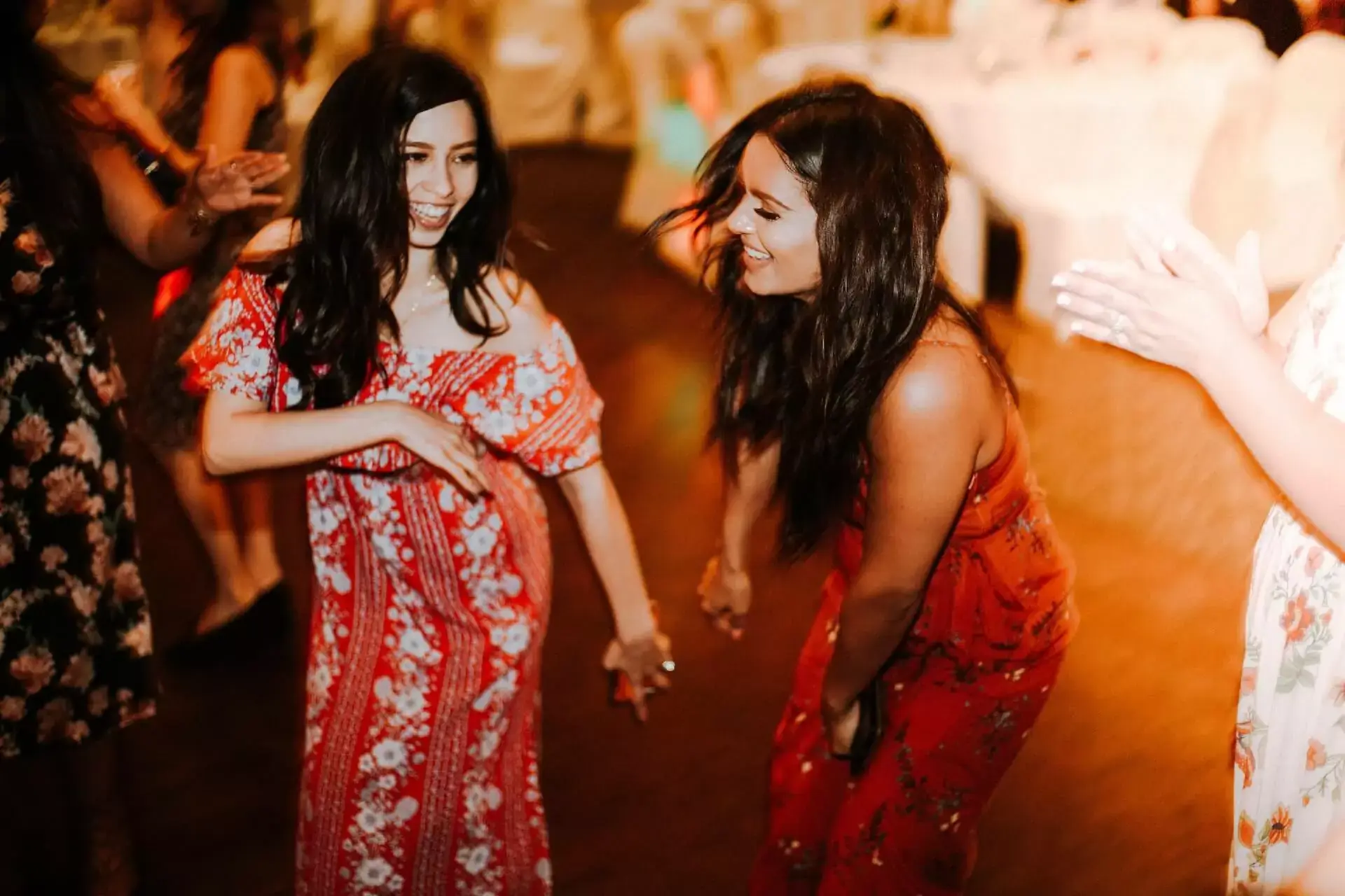 Two women dancing joyfully at an event
