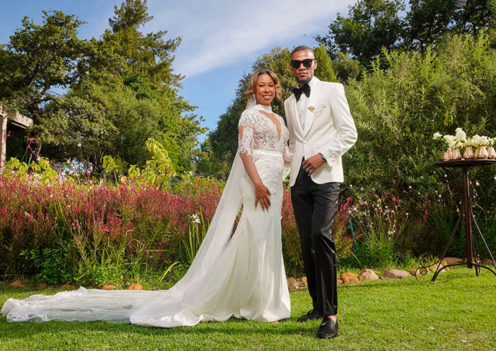 Couple in wedding attire standing in a forest garden