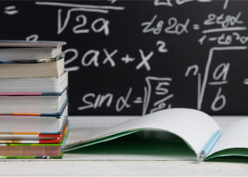 Stack of printed stationery next to open notebook.