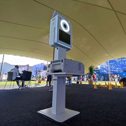 White selfie pod with circular light and screen in a tent