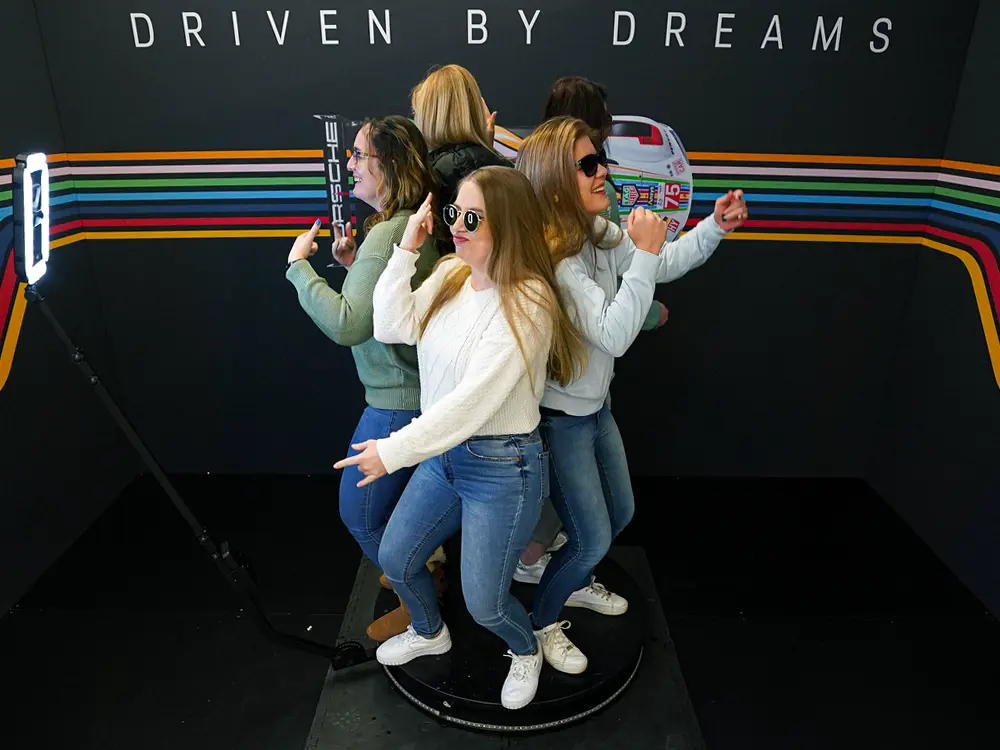 Group of five women posing in a lively photo booth.