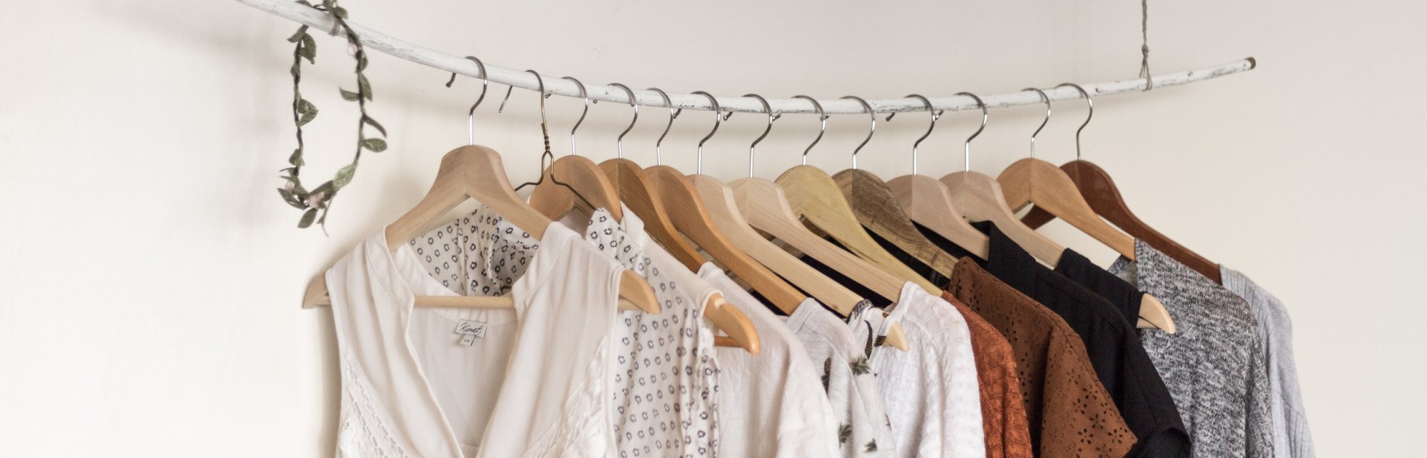 A minimalist clothing rack with hanging garments in various colors.