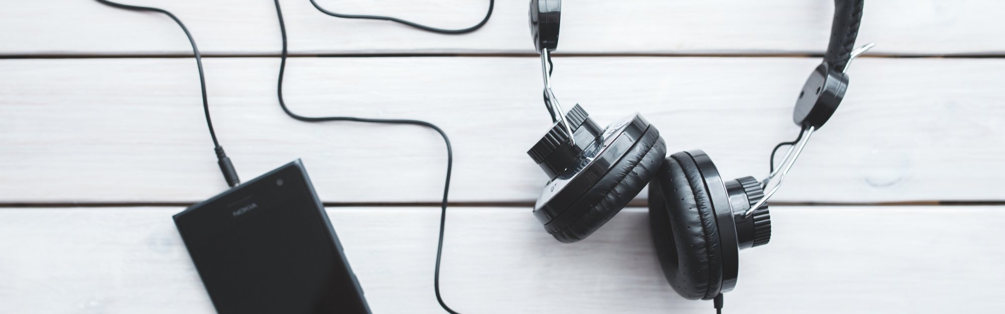 Headphones and smartphone on a wooden surface