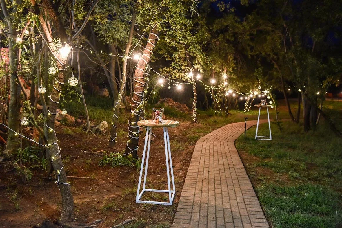 Illuminated pathway with cocktail tables and fairy lights