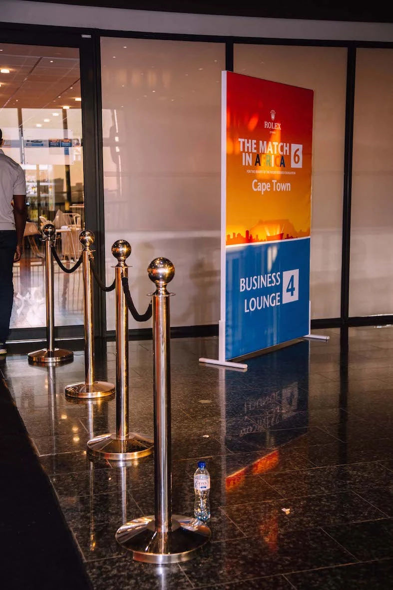 Colorful event signage with stanchions at entrance.