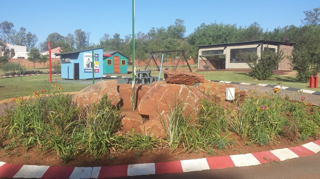 Outdoor kids play area with colorful play equipment and landscaped rocks