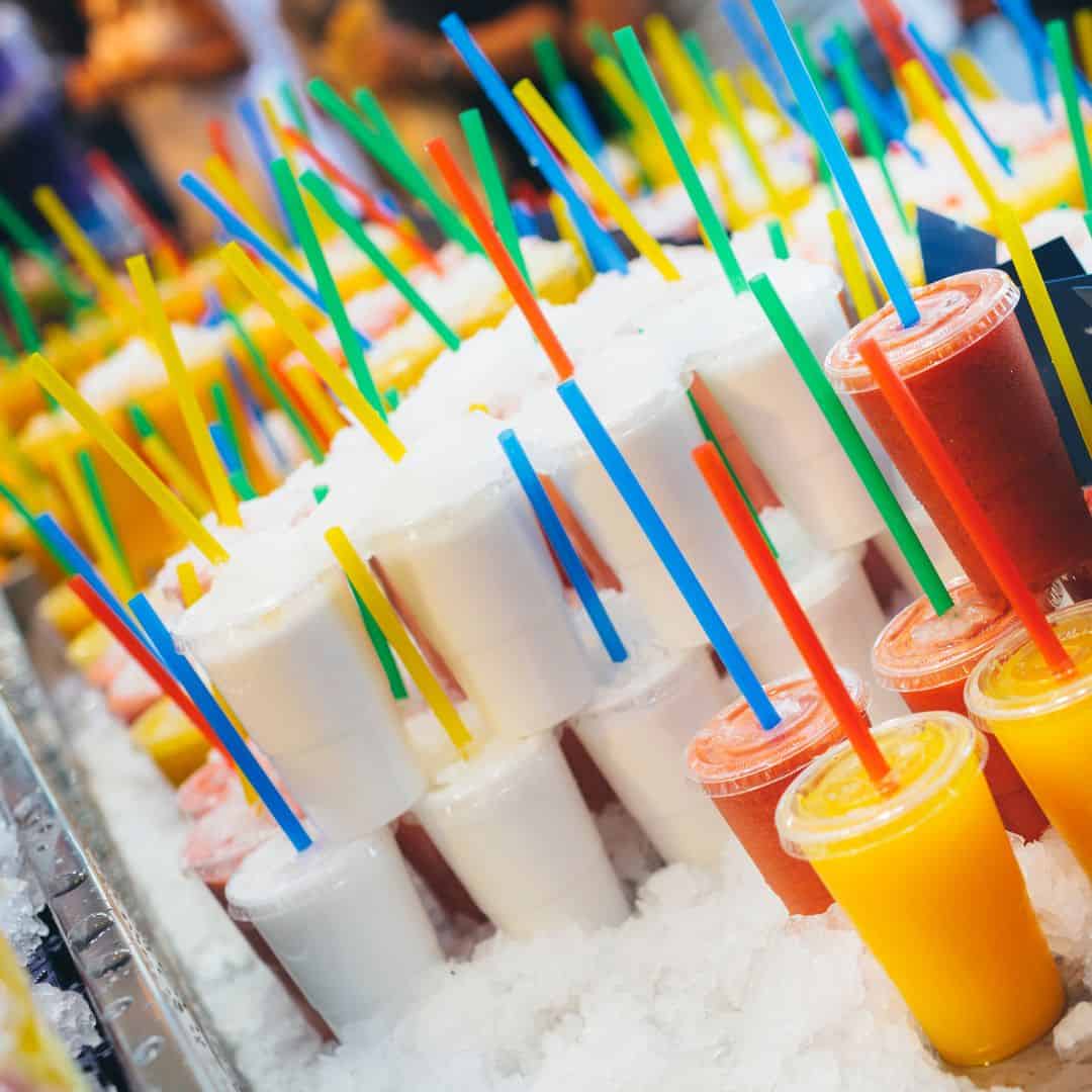 Colorful slushie cups with straws on ice