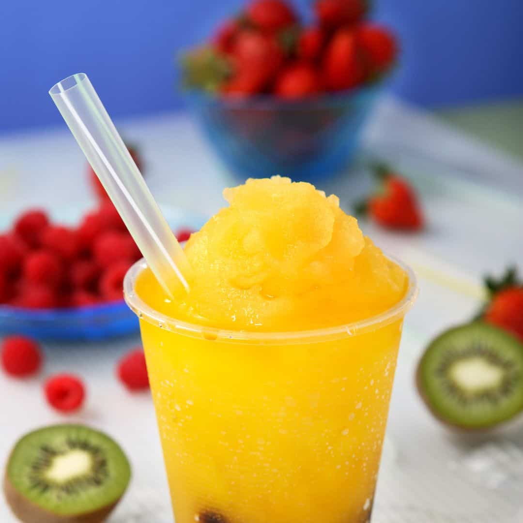 Close-up of a slushy drink with fruit garnishes.