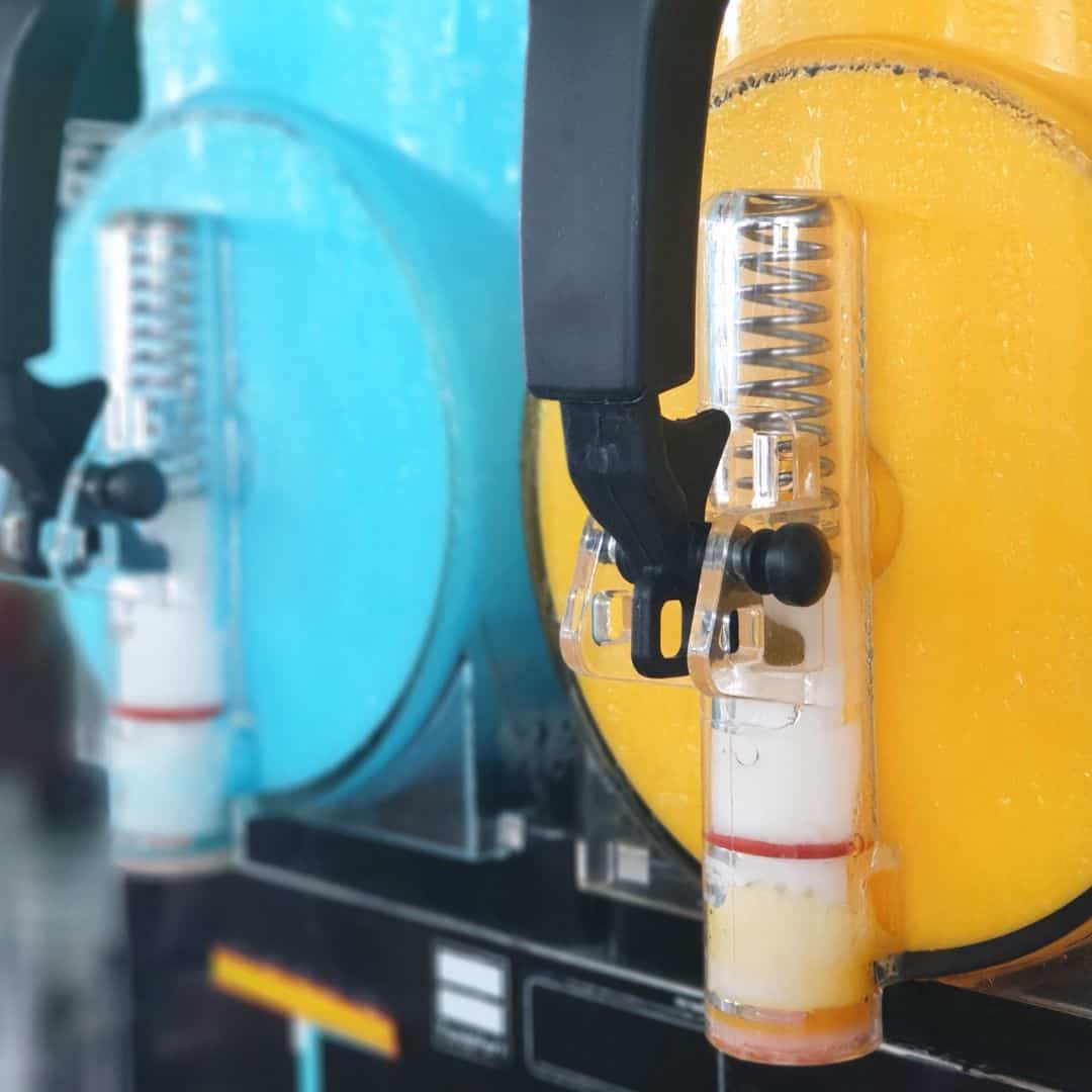 Two slushy machines in bright blue and yellow colors