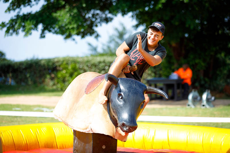 A participant riding a mechanical bull at an outdoor event