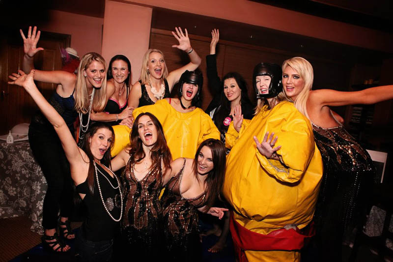 Group of women dressed in festive outfits enjoying a party.