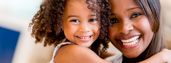 A woman and a girl smiling together