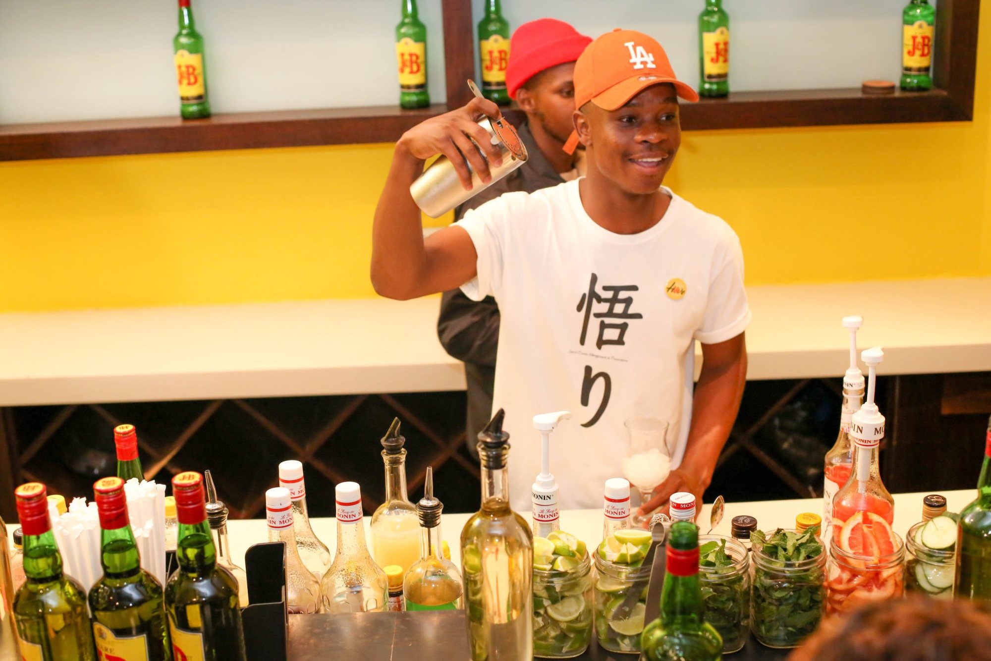 Bartender shaking a cocktail behind a mobile bar.