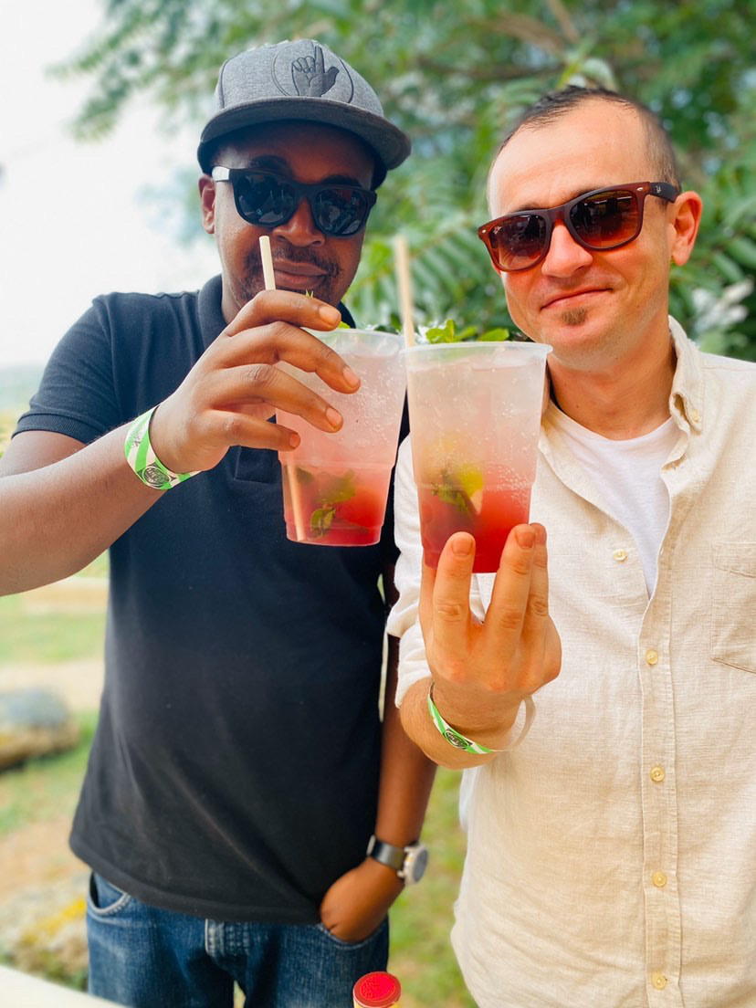 Two men toasting with cocktails in an outdoor setting.