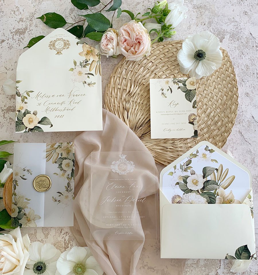 Floral-themed wedding invitation suite with envelopes and decor elements