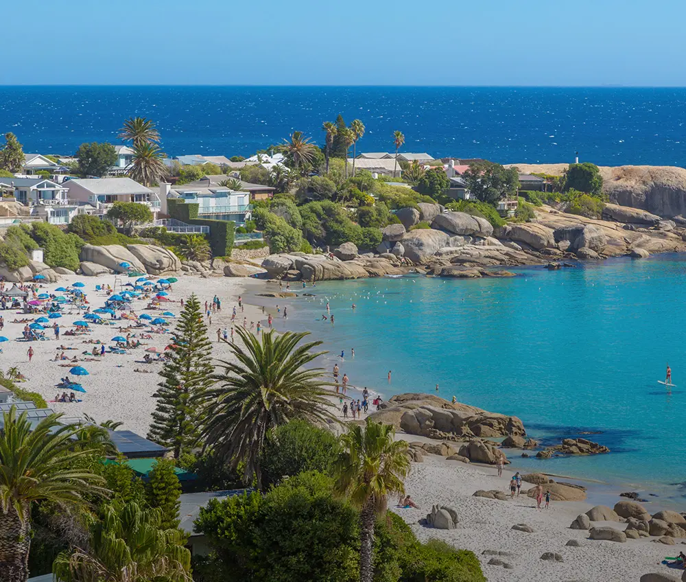 A scenic beach view with clear blue water and sandy shores.