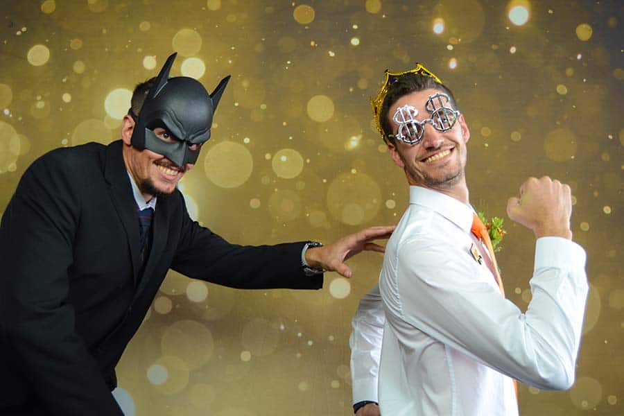 Two guests posing with props in a photo booth setup