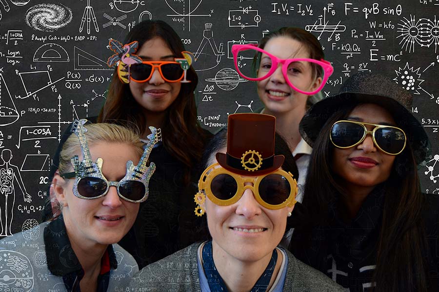 Group of people wearing colorful glasses in a photo booth