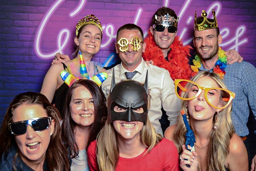 Group of people enjoying a photo booth with props