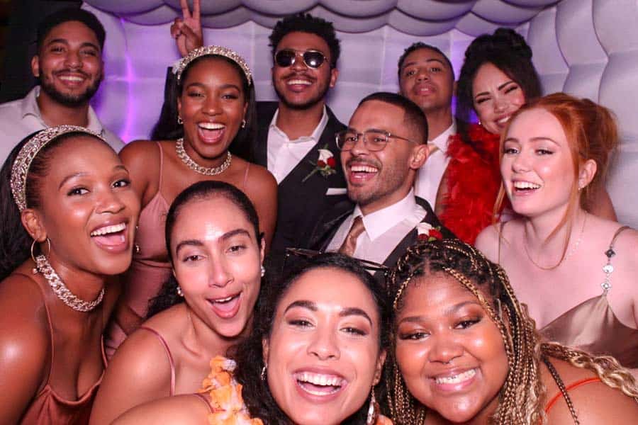 Group of friends laughing and posing in a photo booth.
