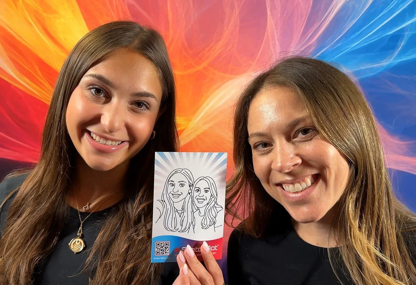 Two women displaying a printed digital sketch.