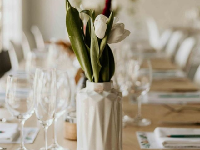 White tulips in a decorative vase on a wooden table