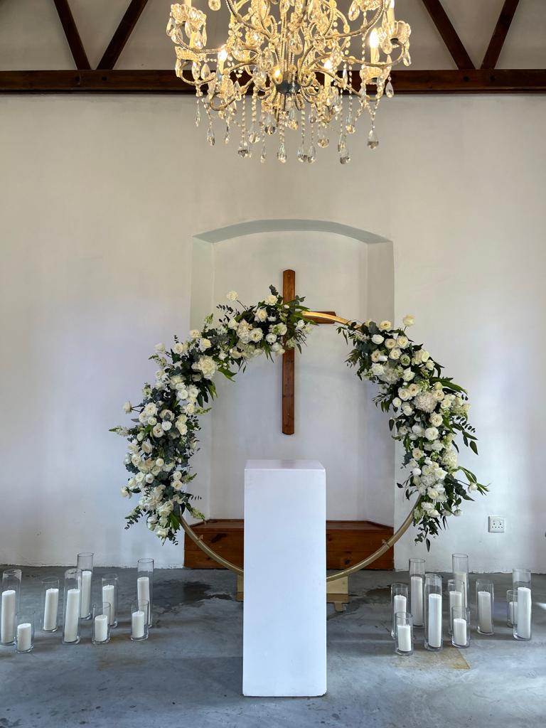 Floral arch with white flowers and candles at a venue