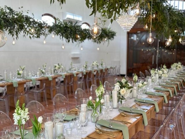 Long dining table with floral arrangements and hanging lights