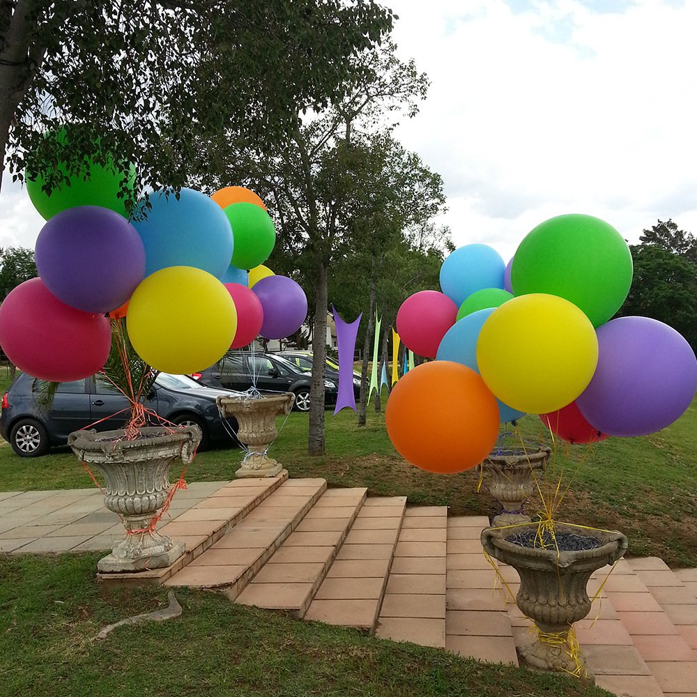 Colorful balloons in a garden setting near decorative pots