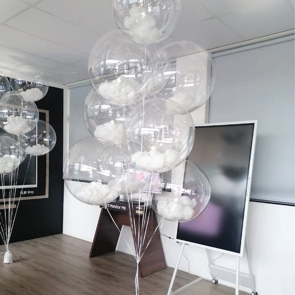Clear balloons filled with white decor on display