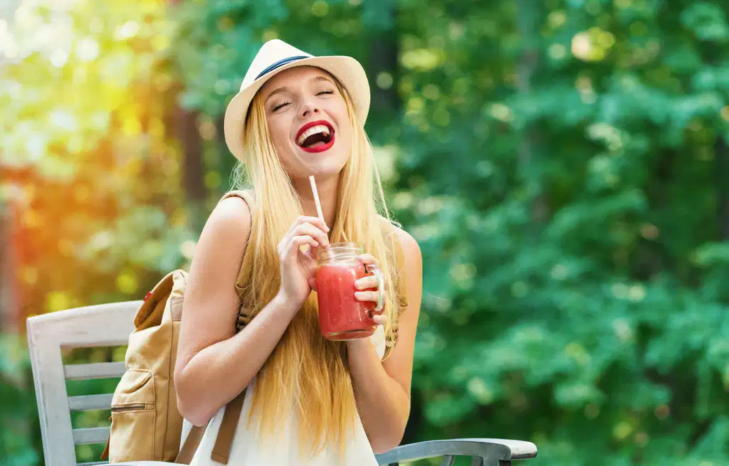 Young woman enjoying a fruity slush drink outdoors