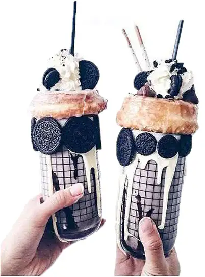 Two oversized dessert jars with cookies and cream toppings
