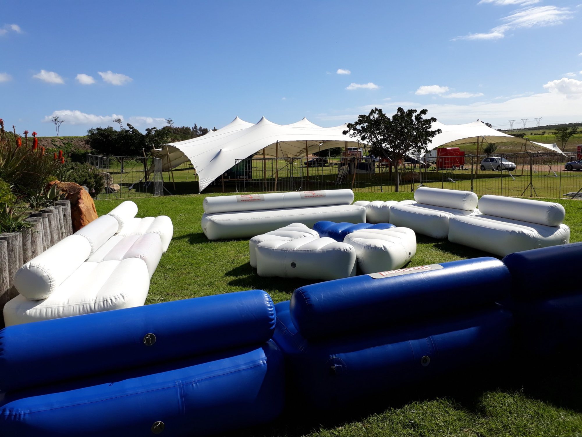 Inflatable lounge seating arranged outside under stretch tents