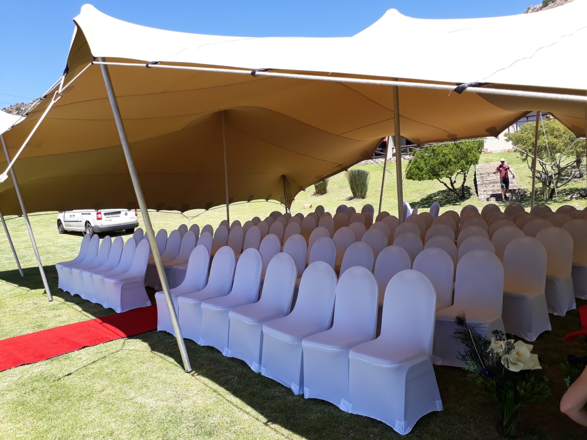 Outdoor stretch tent with rows of white chairs