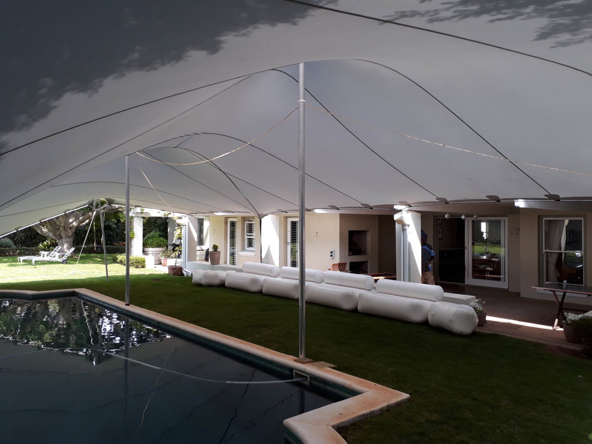 Large stretch tent setup by a poolside with modular seating