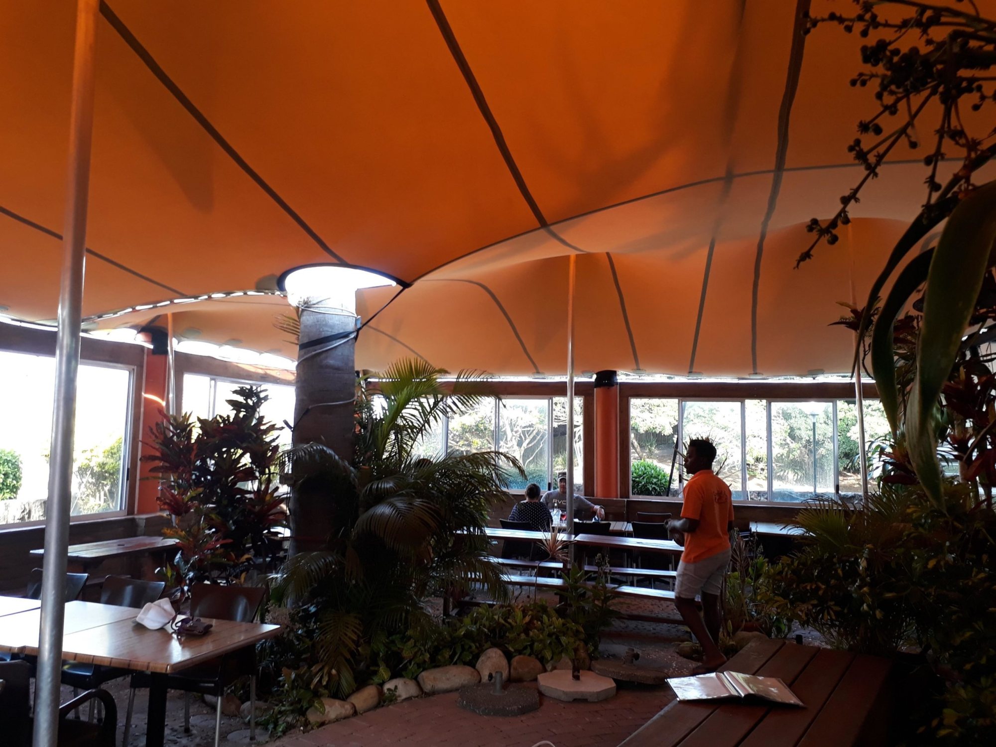 Inside view of a stretch tent setup with seating and greenery