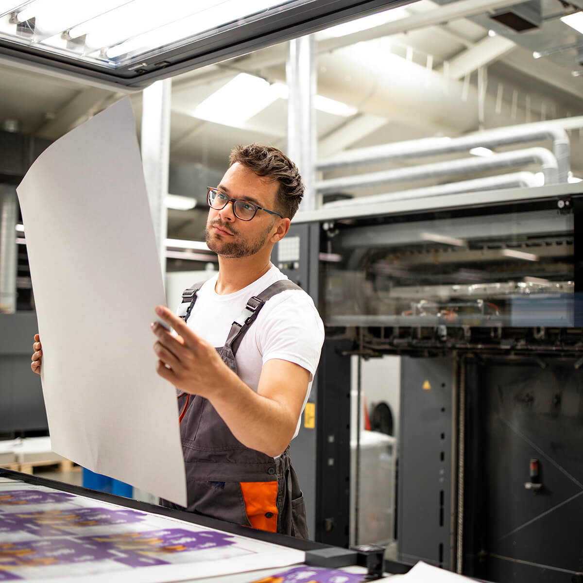 Man inspecting printed sheets in a print studio