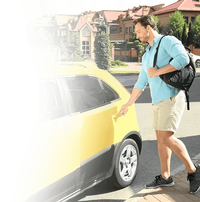 A man opening the door of a yellow car, ready to enter.