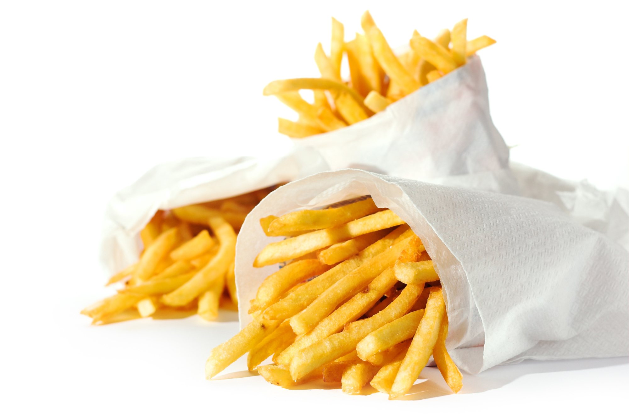 Three paper cones filled with crispy French fries