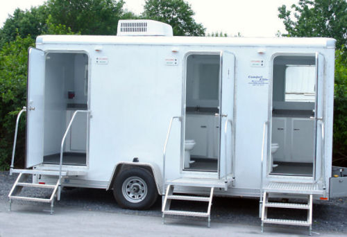 White portable toilet trailer with two access doors.
