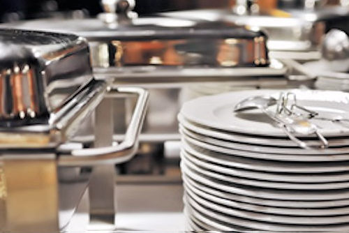 Stainless steel chafing dishes and stacked white plates