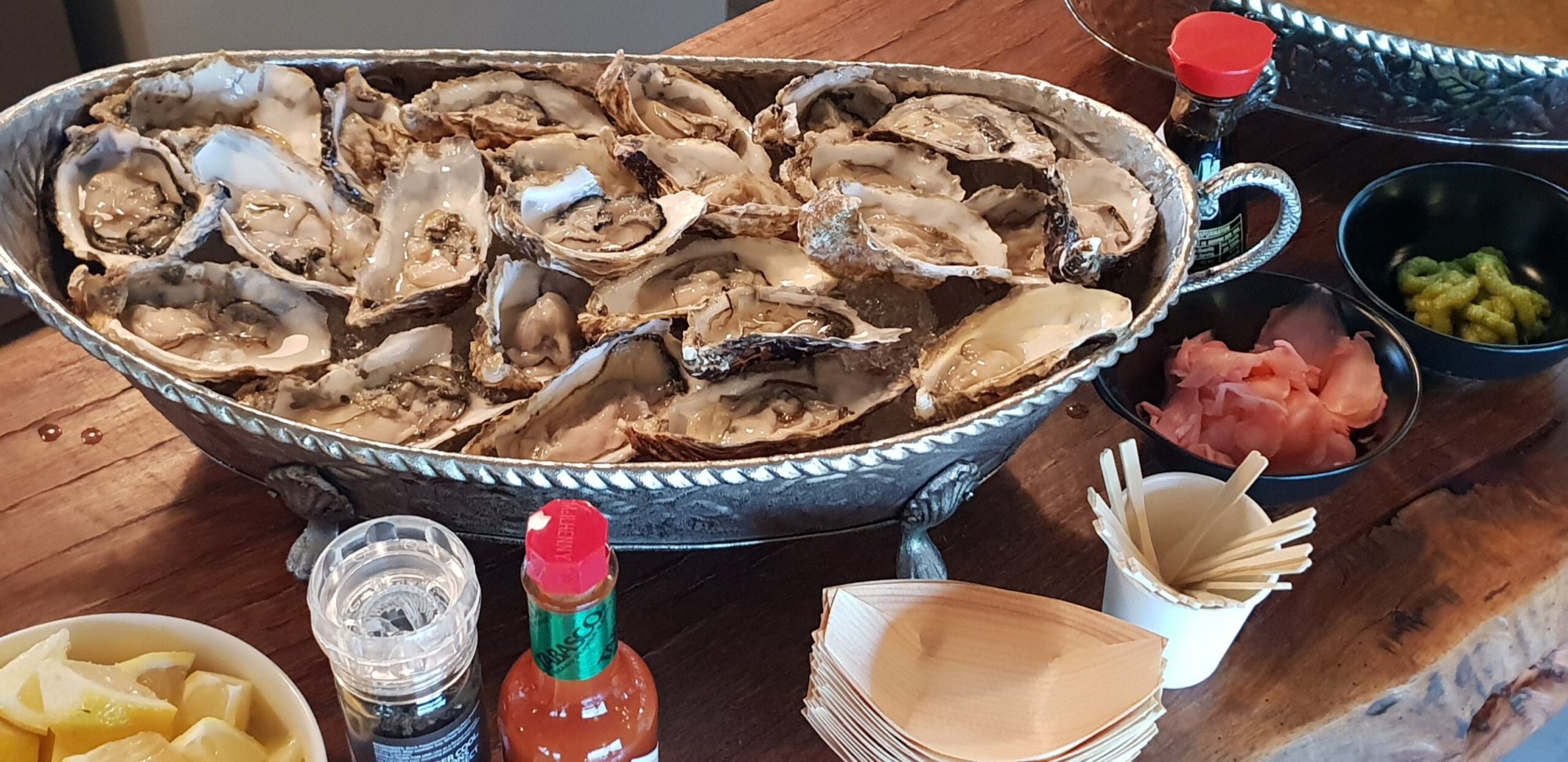 A decorative oyster platter with condiments and garnishes